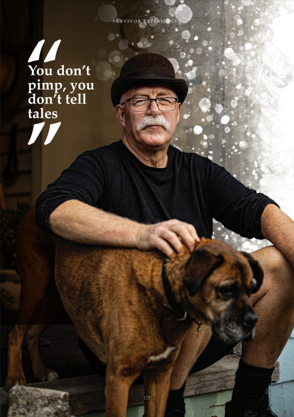 Jim Goodwin, wearing a black top and hat, sitting on a step with his dog beside him